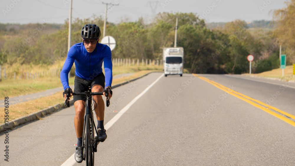 Obraz premium Man riding bicycle on a road outdoors