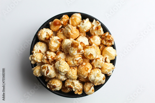 Caramel popcorn, in a black bowl, isolated on white background, flat lay or top view
