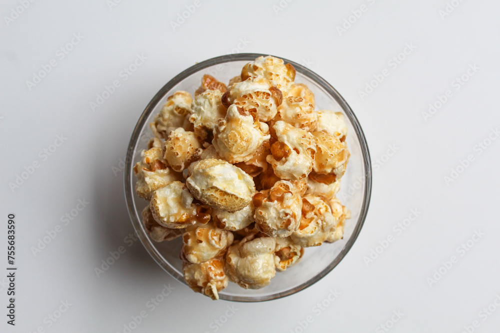 Caramel popcorn, in a transparent glass bowl, isolated on white background, flat lay or top view Caramel popcorn, in a transparent glass bowl, isolated on white background, flat lay or top view