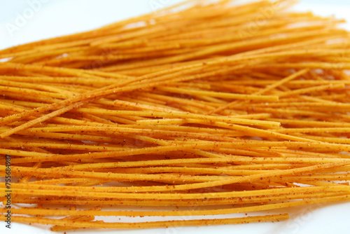 Mie lidi pedas, traditional snack from Indonesia. Noodle-like texture, fried and coated with chili powder photo