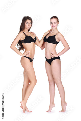 Two girls in black underwear pose isolated on white background