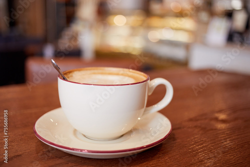 Cup of coffee on wooden table in cafeteria