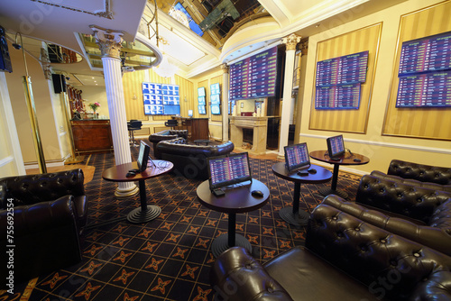 Fototapet Tables with gaming computers and lot of screens in bookmaker office of casino, m