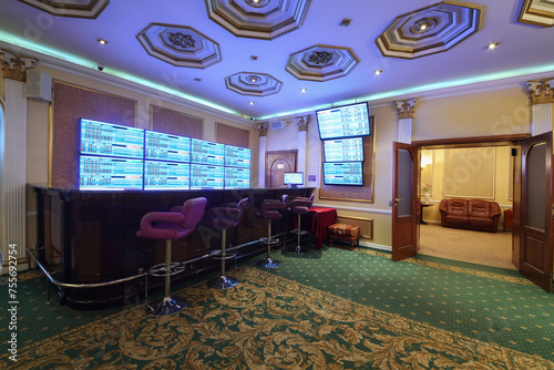 Schilderij op canvas Empty wooden counter and lot of screens in luxury bookmaker office with carpet,