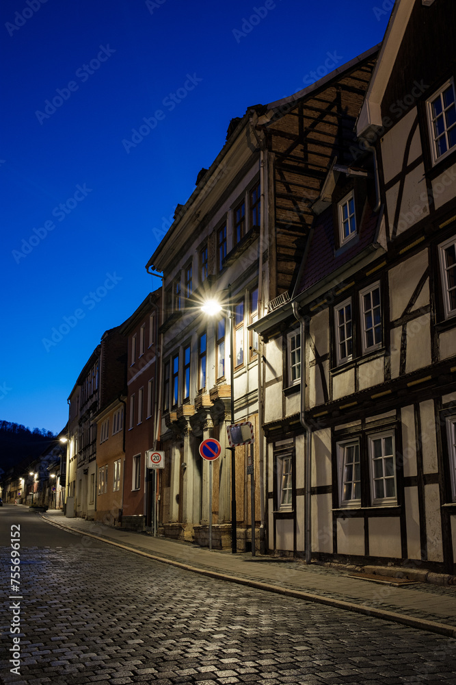 Street alley in the small town of Schwabisch Hall, with houses and buildings with typical German architecture and street lanterns, at night.