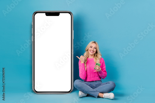 Full body photo of young targetologist girl targetologist recommend her web service phone screen buy ads isolated on blue color background © deagreez