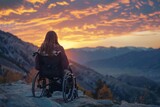 An individual in a wheelchair takes in the breathtaking view of a mountainous sunset, reflecting a moment of peace and the beauty of nature