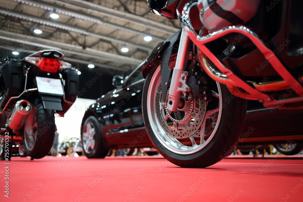 Black bikes for cortege, car are on red carpet in exhibition, close up