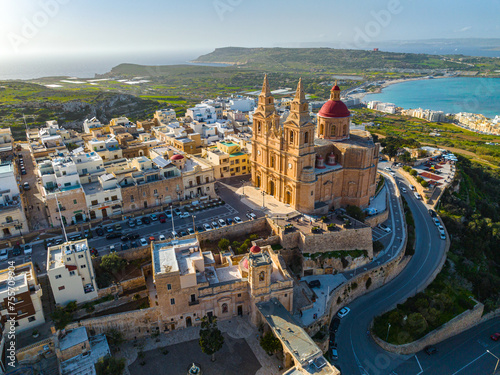 Aerial drone view of The Parish Church in Mellieha city and road. Blue sky, sea, day. Maltese island #755709904