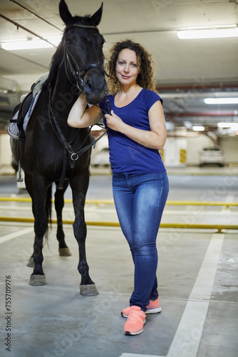 Young woman with horse at underground parking