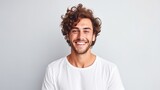 A captivating portrait of a cheerful young man with curly hair and a stylish beard in a white t-shirt, perfect for modern marketing campaigns with a positive and youthful appeal.