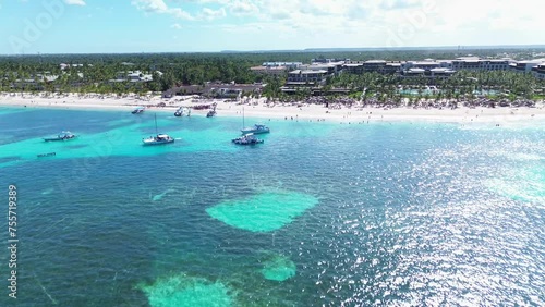 Aerial flight above the public Bavaro beach with white sand. Turquoise water of the Caribbean sea and tourist yachts and boats. Punta Cana, Dominican republic photo