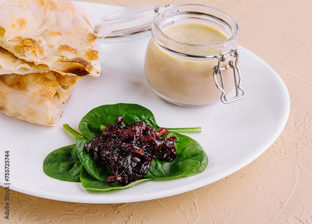 chicken pate with onion jam and pita bread served in a white plate chicken pate with onion jam and pita bread served in a white plate