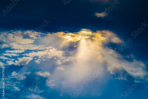 A pillar of sunlight comes from a gap in the clouds. Dark sky with a ray of light. Background on the theme of hope and faith.