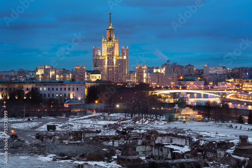 Apartment house on Kotelnicheskaya Embankment and place for construction on site hotel Russia in Moscow in evening
