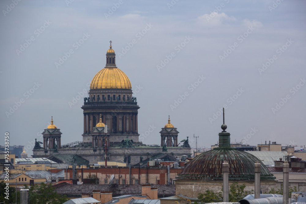 Isaac Cathedral among roofs of buildings, St Petersburg, Russia at night