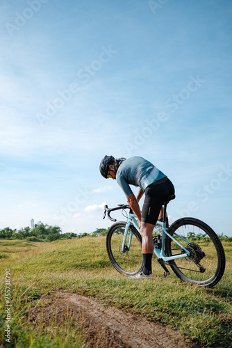 A middle age man drinking water in his gravel bike.