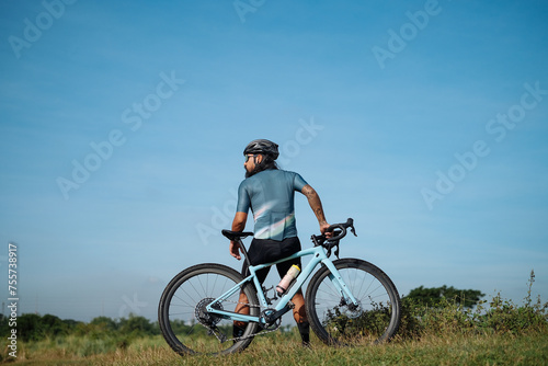 A middle aged bearded cyclist with his gravel bike.