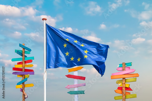 Waving flag of the European Union with colorful wooden direction signs