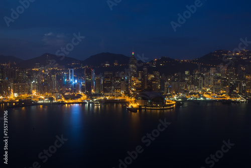 Skyscrapers with bright illumination, shore and mountains in Hong Kong, China at dark night, view from New World Center © Pavel Losevsky