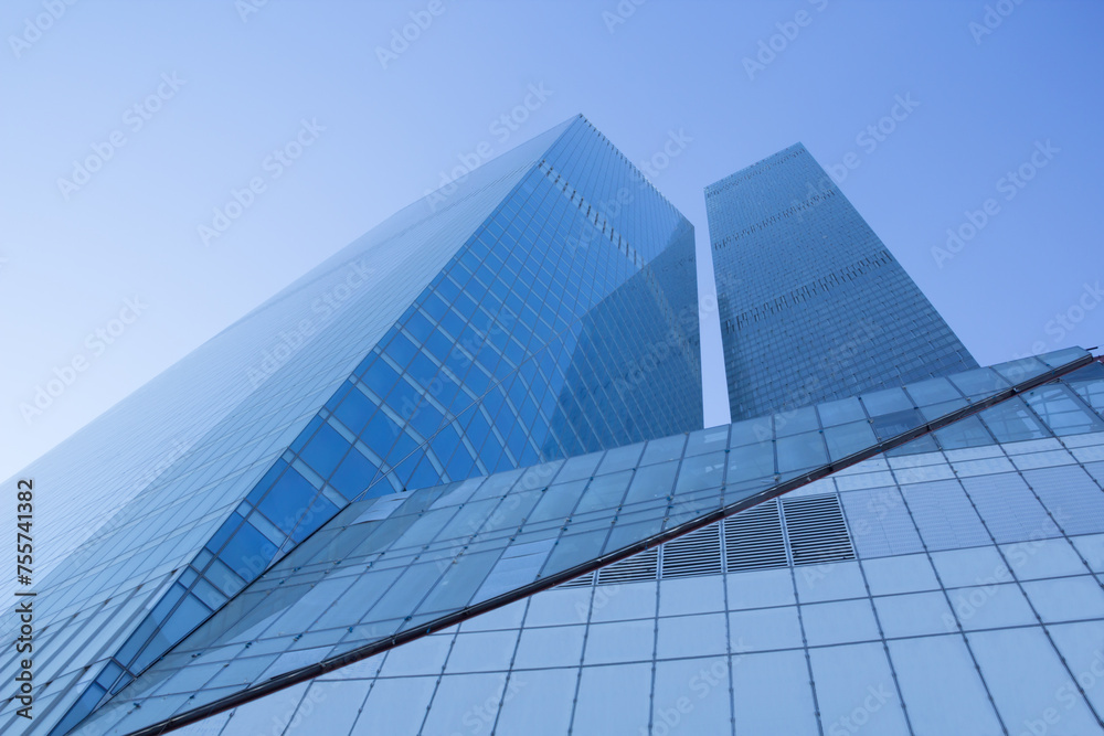 Tall glass blue buildings with many windows and blue sky
