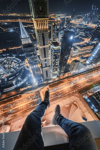 Male legs of rooftop of Millennium Plaza Hotel Dubai on Sheikh Zaid Highway, Tower, Al Yaqoub Tower, Capricorn Tower, Maze Tower, Dubai, UAE at night photo