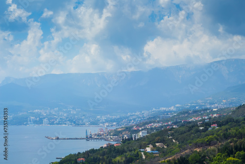 Coast of sea, resort town and green mountains at hot summer day © Pavel Losevsky