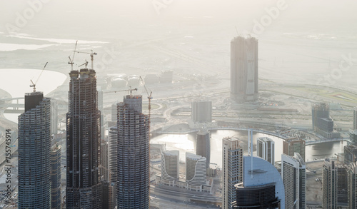 Buildings under construction in Business Bay area, desert far away in Dubai, United Arab Emirates