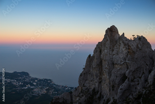 Picturesque resort town near sea shore, big rock at summer evening photo