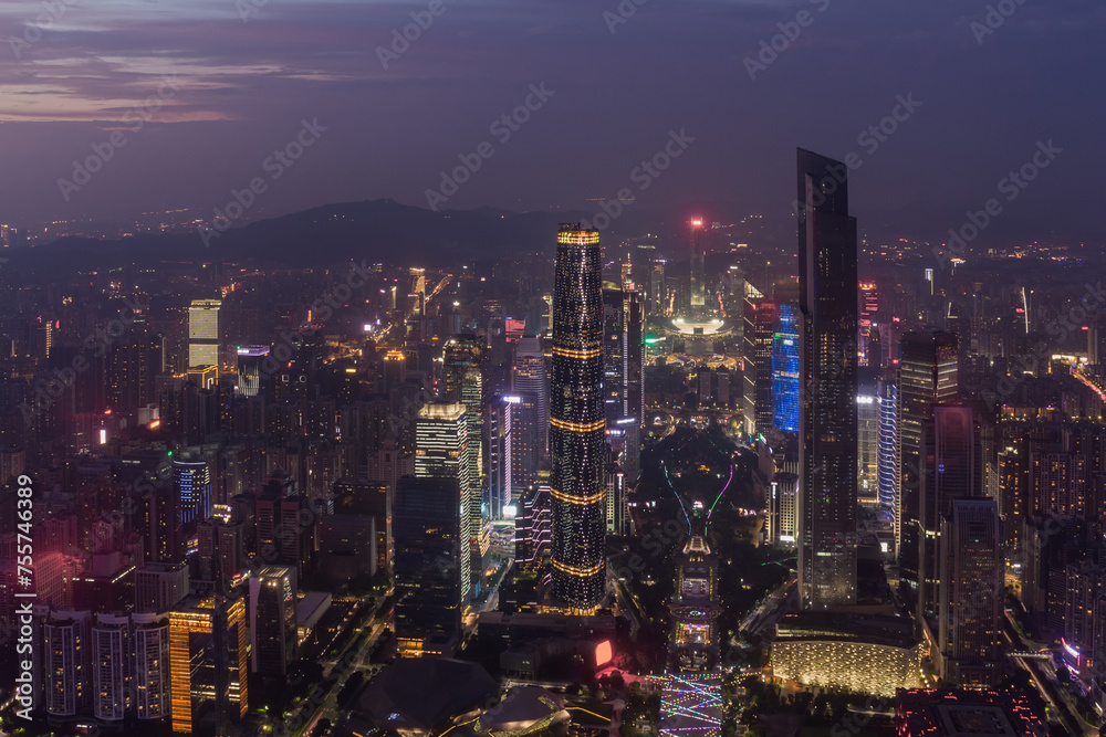 Big modenr Guangzhou city with illumination in fog, China, mountains far away