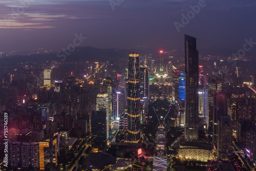 Big modenr Guangzhou city with illumination in fog, China, mountains far away photo