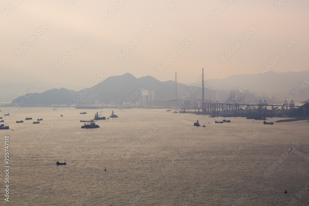 Many ships and boats in sea near cable-stayed in fog in Hong Kong, China, view from China Merchants Tower