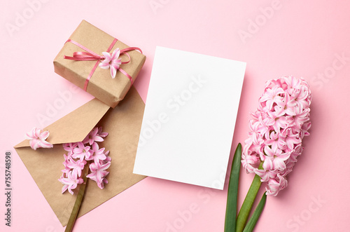 Fototapeta Naklejka Na Ścianę i Meble -  Blank greeting card mockup with pink flowers, envelope and gift box