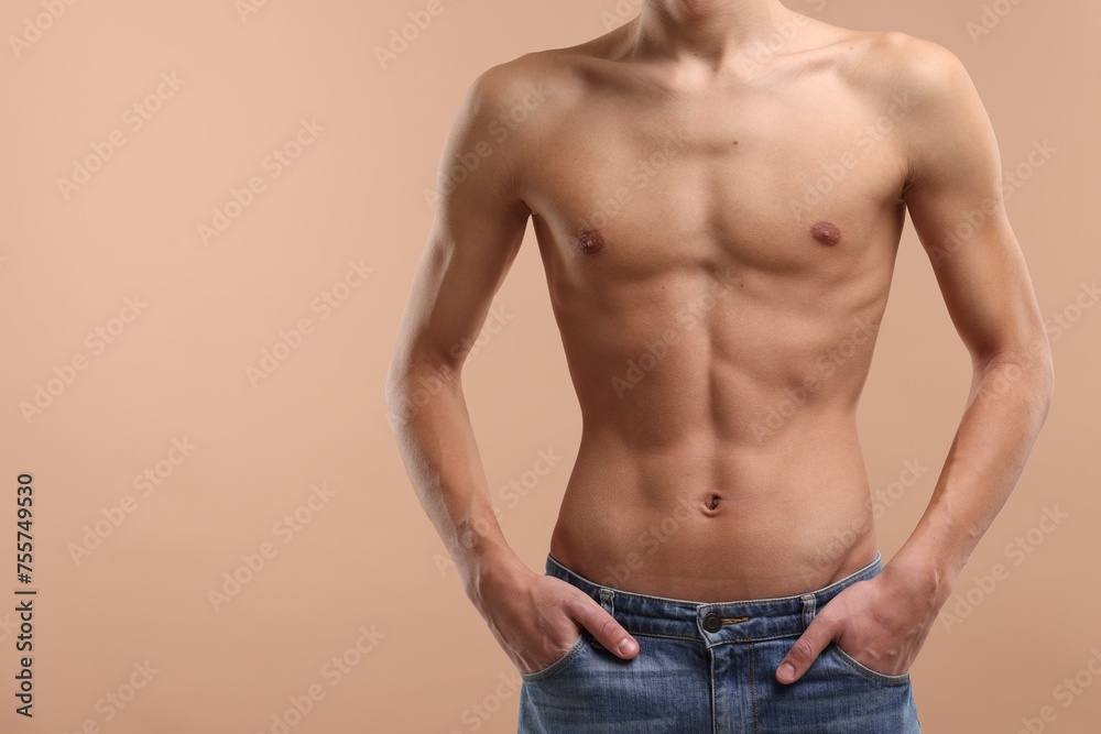 Shirtless man with slim body on beige background, closeup. Space for text