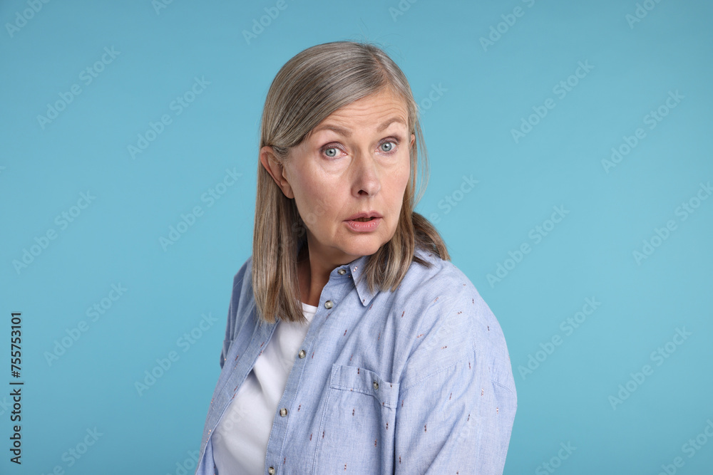 Portrait of surprised senior woman on light blue background Portrait of surprised senior woman on light blue background