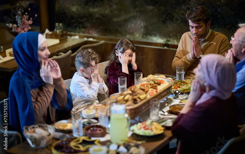 In a modern restaurant setting  a European Islamic family comes together for iftar during Ramadan  engaging in prayer before the meal  uniting tradition and contemporary practices in a celebration of