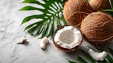Fresh coconut with white flesh on textured background for tropical flavor. Whole and halved coconuts with lush green leaves for natural appeal.