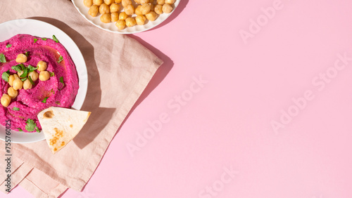 Beetroot hummus on pink background, top view and copy space