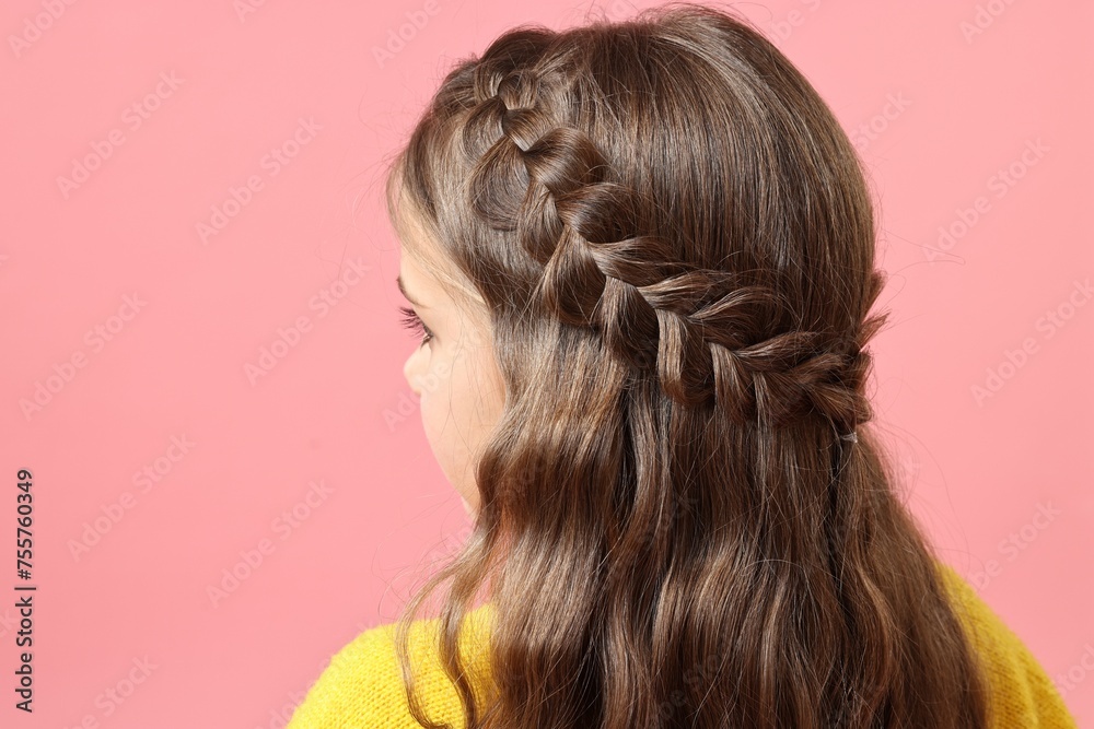 Naklejka premium Little girl with braided hair on pink background, back view