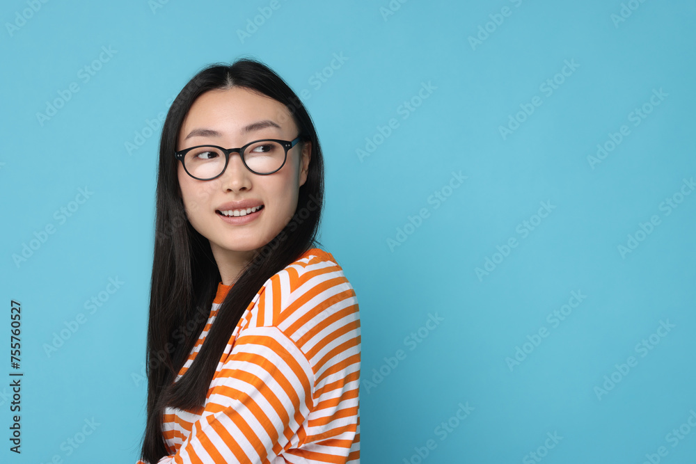 Portrait of happy woman in glasses on light blue background. Space for text Portrait of happy woman in glasses on light blue background. Space for text