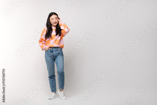 Full length portrait of smiling woman on light background. Space for text © New Africa