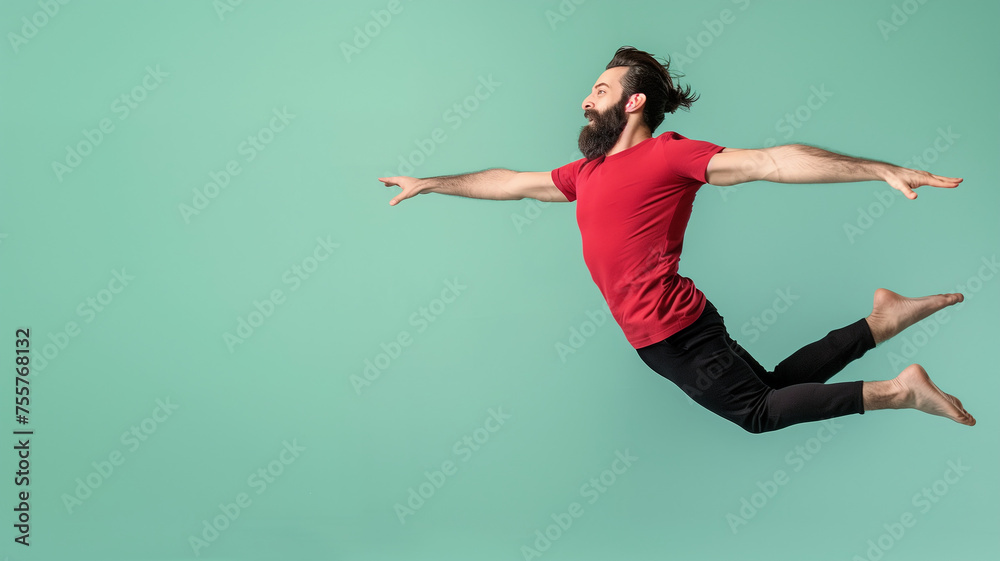 A man with a beard, wearing a red shirt and black pants, flying happily.