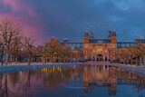 Amsterdam, Netherlands March 25 2022: Amsterdam in a cold night during spring season. Famous national Rijks museum general view reflecting in tha water at dusk