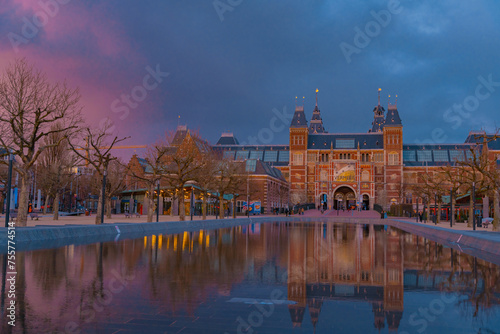 Amsterdam, Netherlands March 25 2022: Amsterdam in a cold night during spring season. Famous national Rijks museum general view reflecting in tha water at dusk