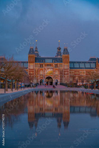 Amsterdam, Netherlands March 25 2022: Amsterdam in a cold night during spring season. Famous national Rijks museum general view reflecting in tha water at dusk photo