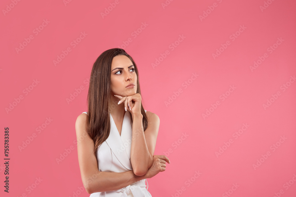 Pensive girl in blouse touching chin, looking at upper right corner and thinking, making choice. Copy space Pensive girl in blouse touching chin, looking at upper right corner and thinking, making choice. Copy space
