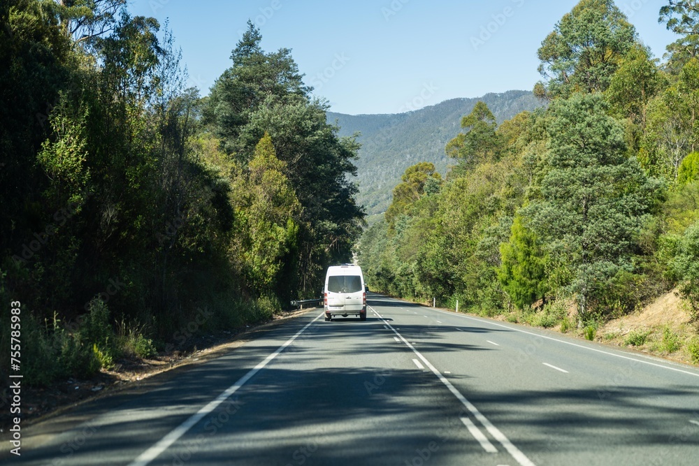tourist traveling in a caravan exploring nature driving on a raod in the forest Cars Driving on a highway road, in australia - obrazy, fototapety, plakaty 