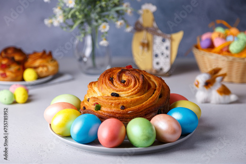 Craffin (Cruffin) with raisins and candied fruits. Traditional Easter Bread Kulich and painted eggs on a gray background. Easter Holiday. Close-up, selective focus. photo