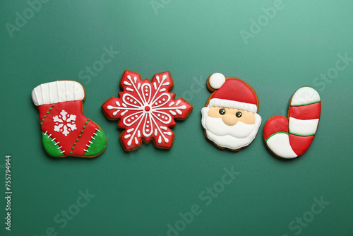 Different tasty Christmas cookies on green background, flat lay