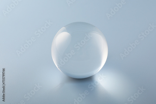 Transparent glass ball on light grey background